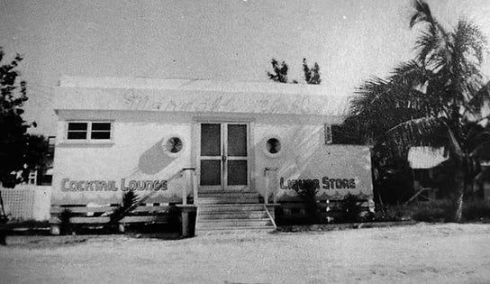A black and white photo of a building that says cocktail lounge