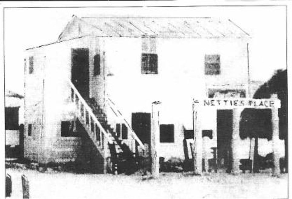 A black and white photo of a building that says nestles place