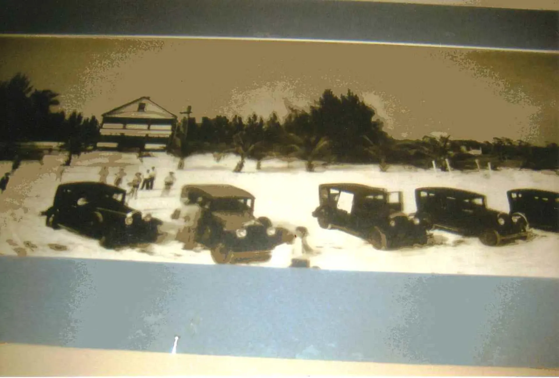 A black and white photo of cars parked in the snow