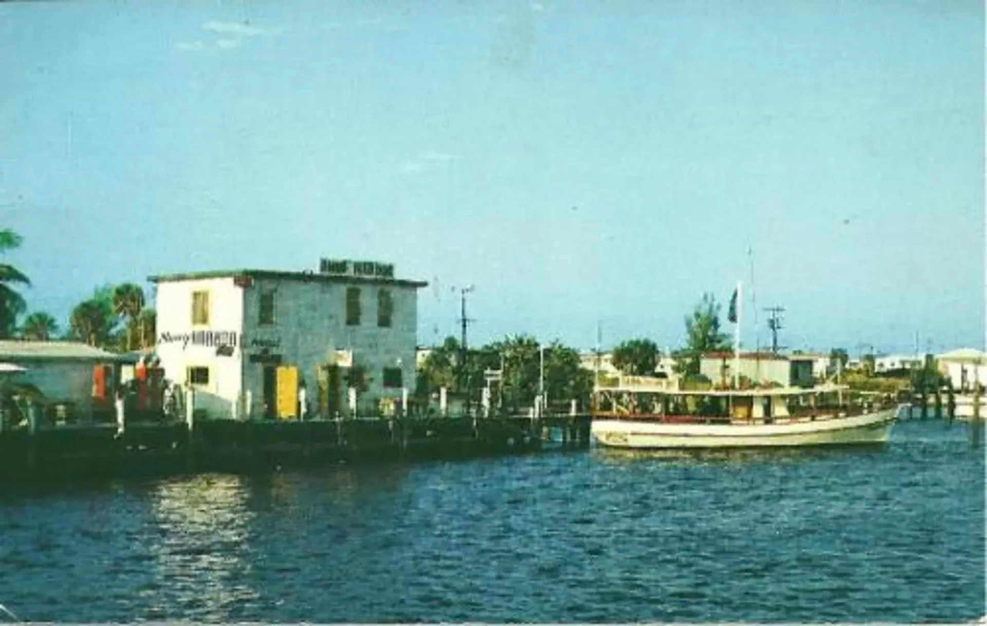 A boat is docked at a dock with a building in the background