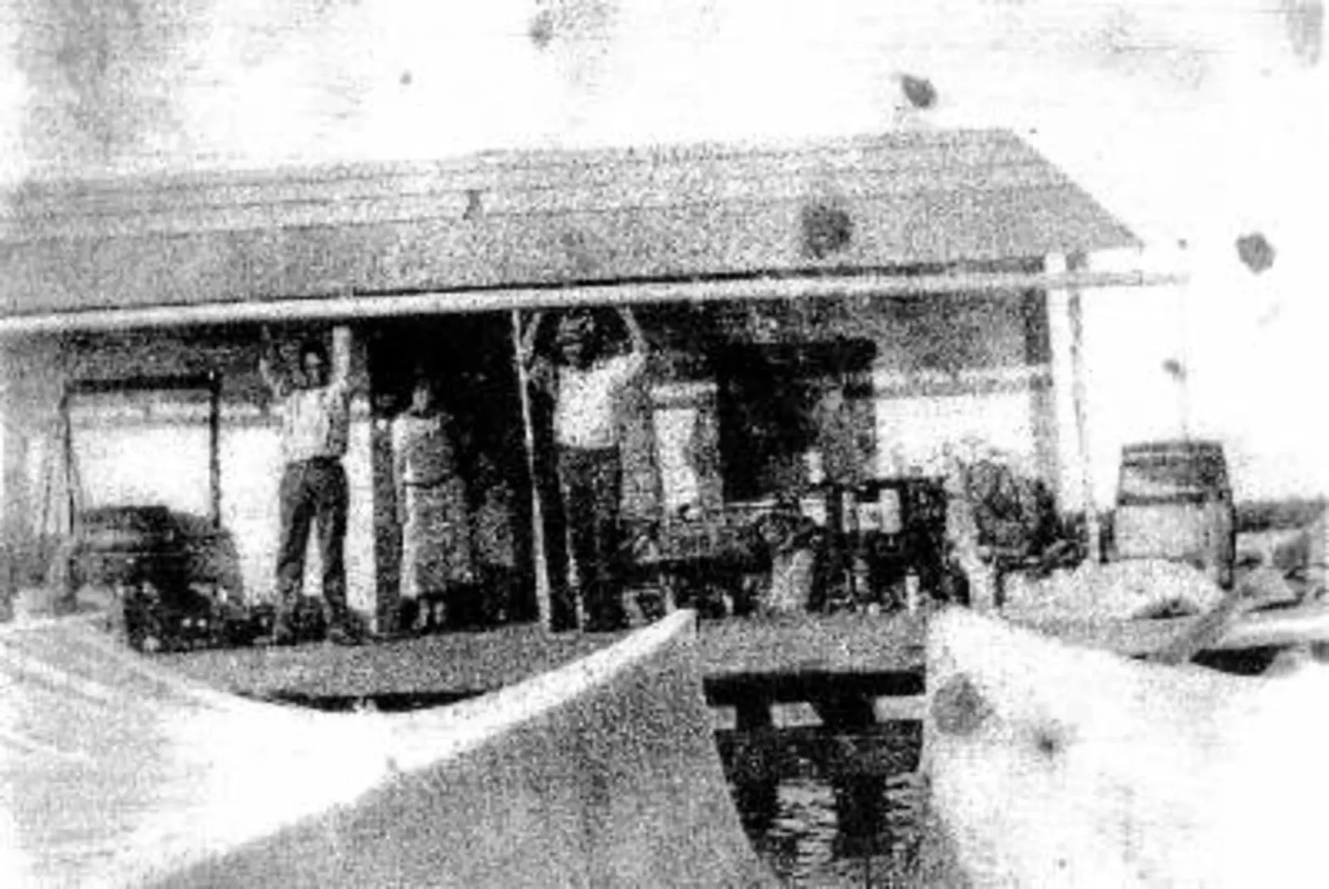 A black and white photo of a group of people standing in front of a building.