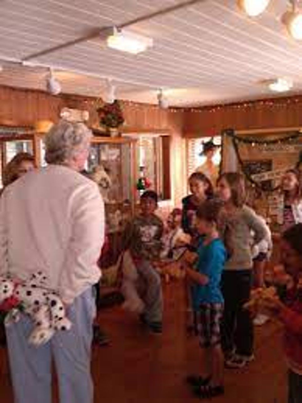 A group of people are standing in a room talking to each other.