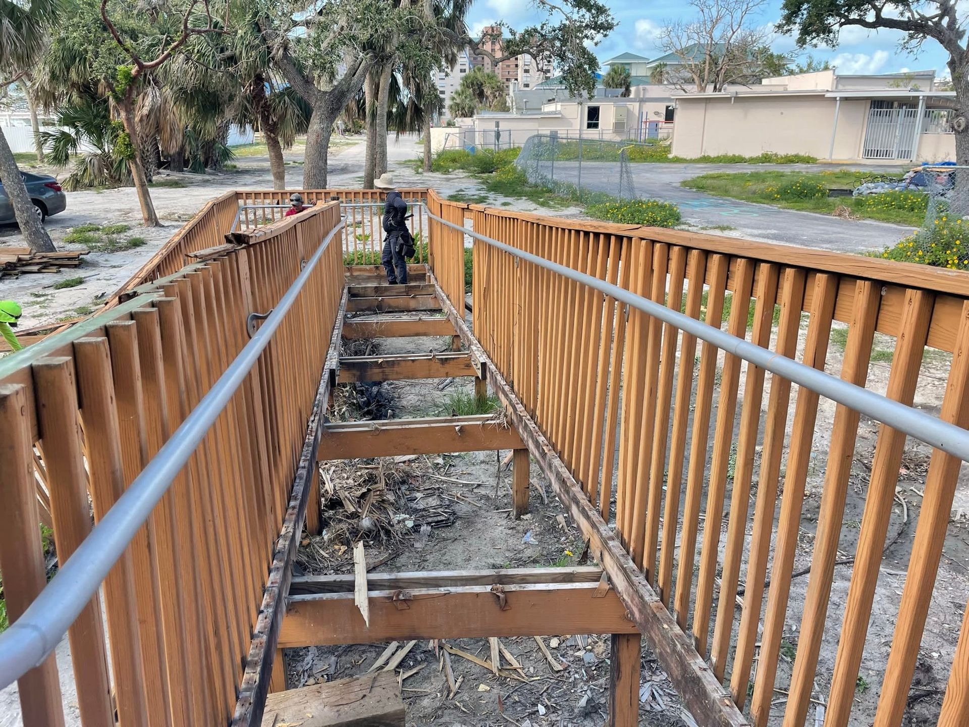 A wooden walkway with a metal railing is being built.