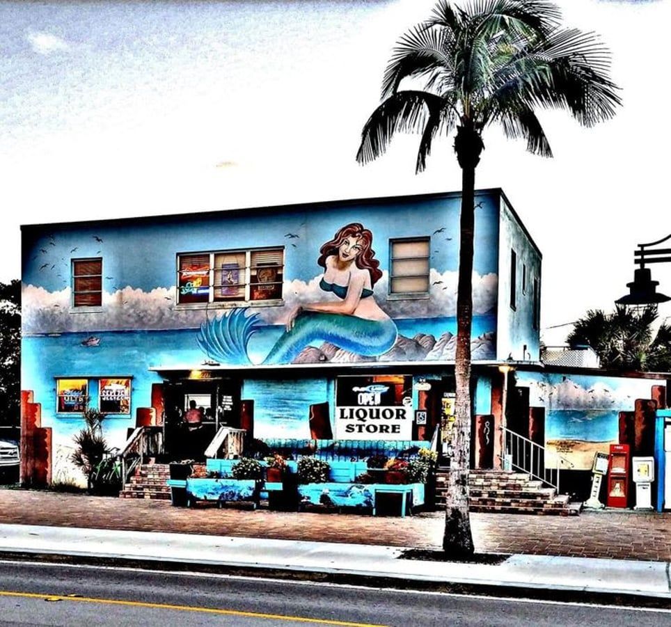 A liquor store with a mermaid painted on the side