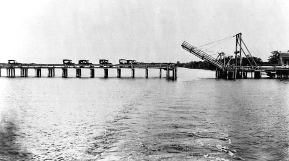 A black and white photo of a bridge over a body of water