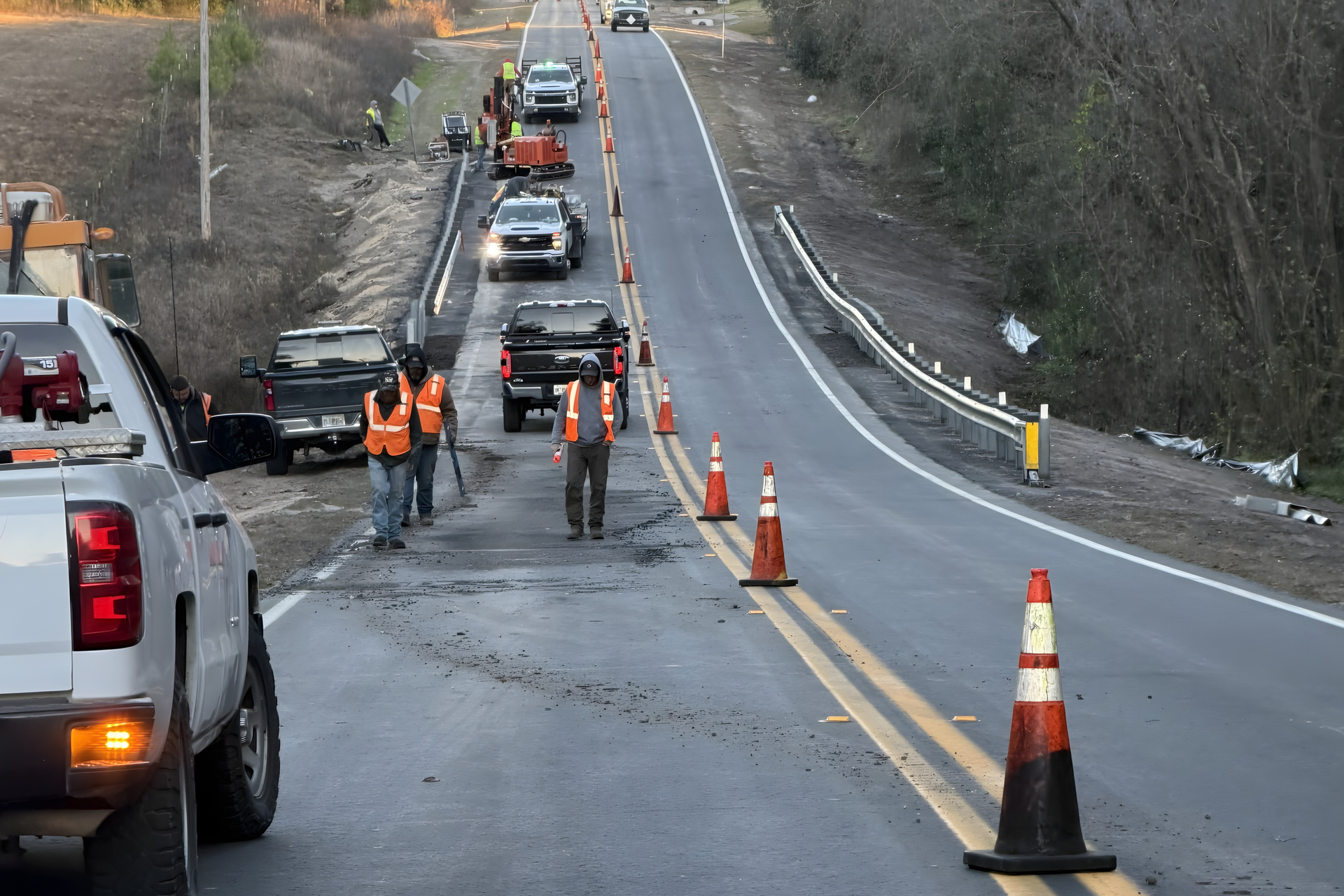 Road construction crew performing traffic control and ongoing road maintenance