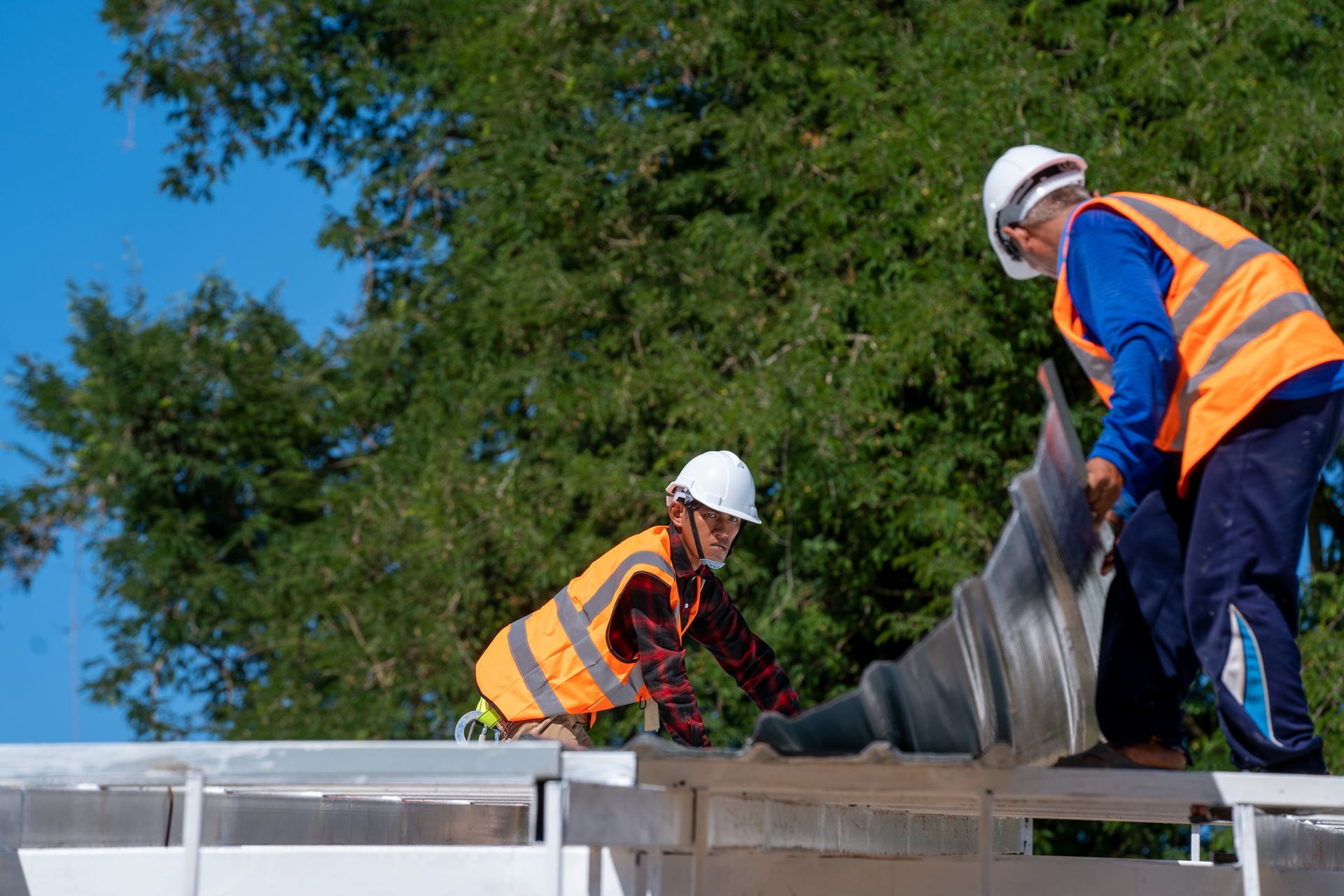 Workers installing roadside guardrail for highway safety and protection