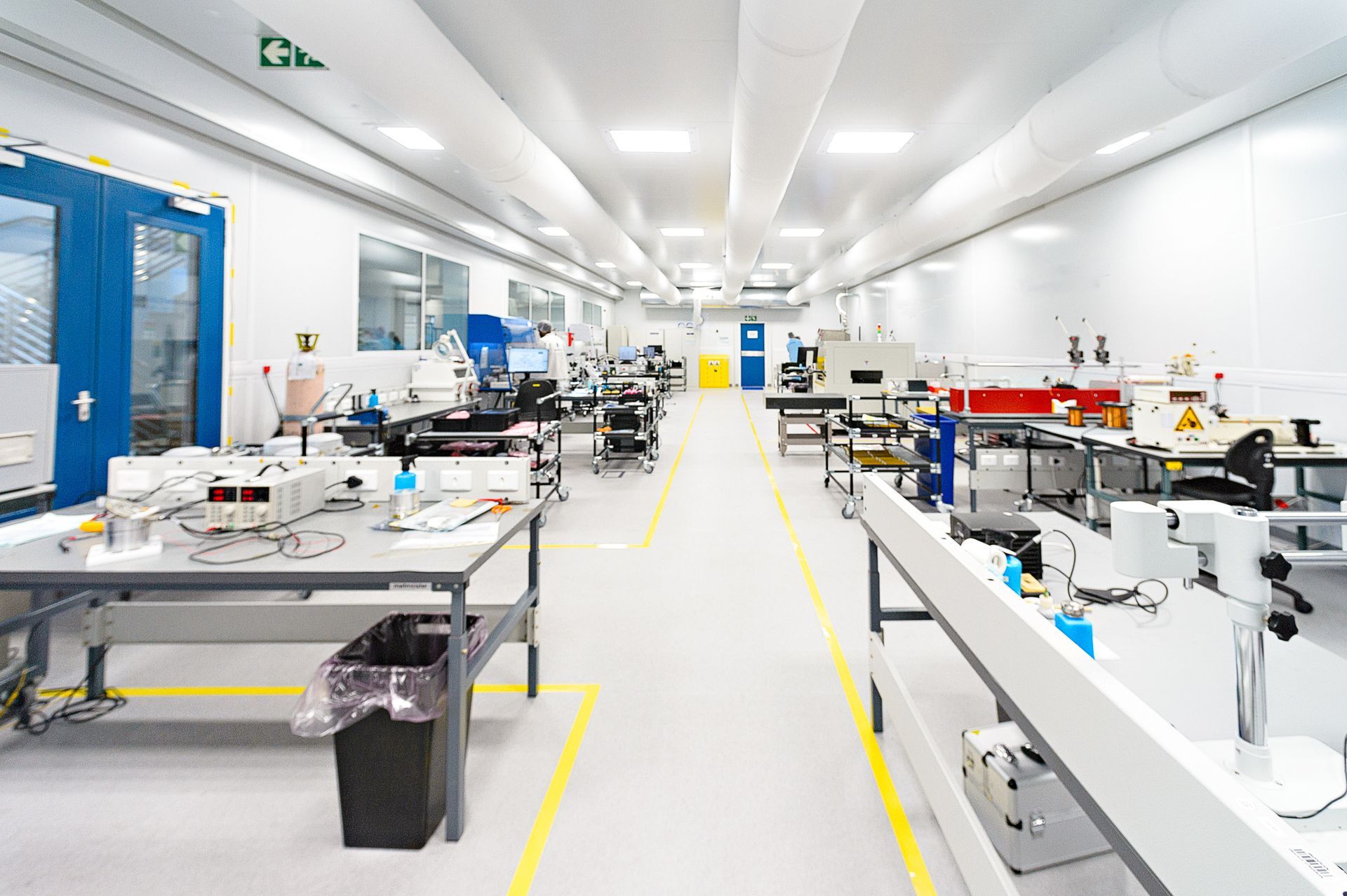 A large room with lots of tables and chairs in a factory.