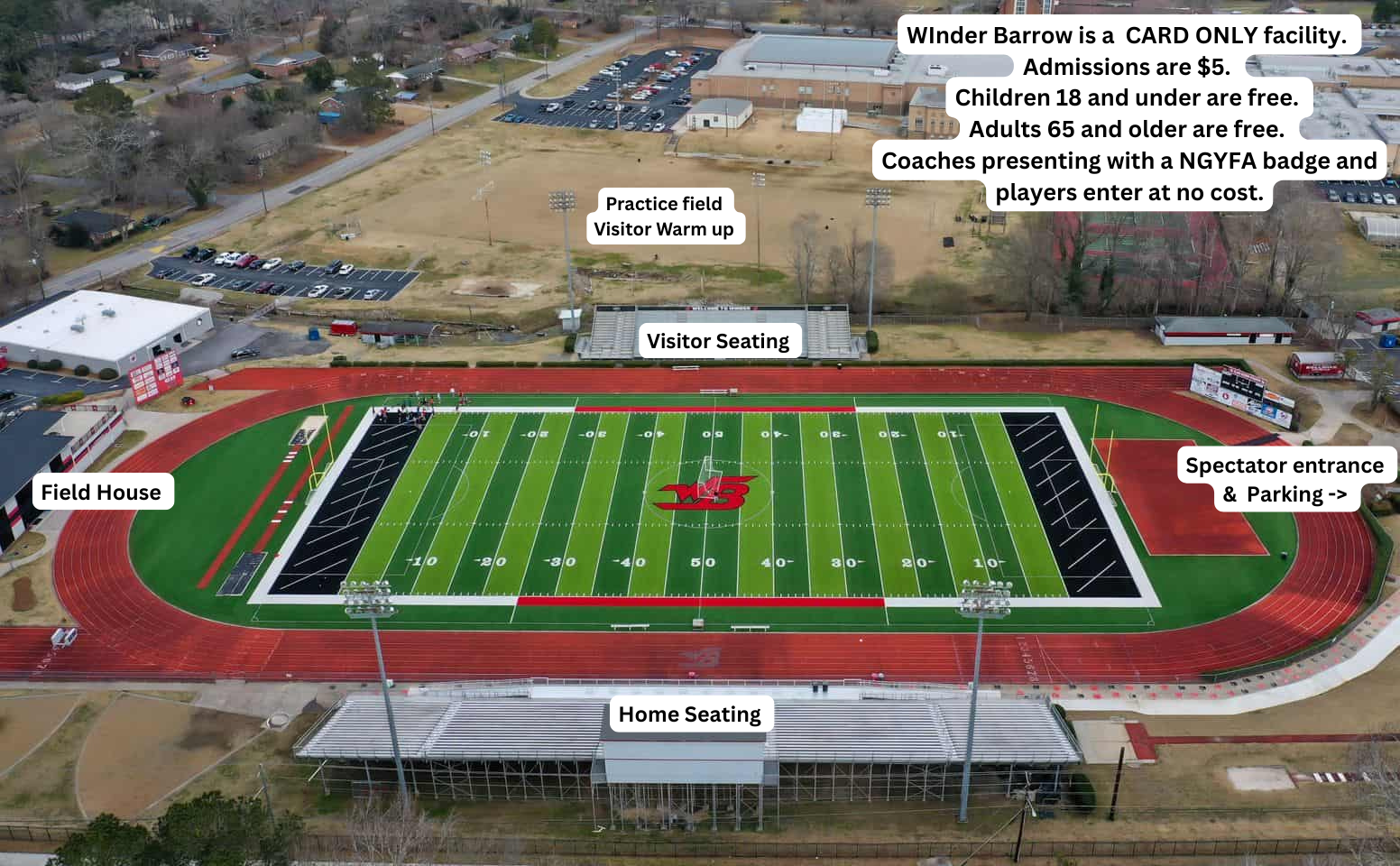 Aerial view of a football stadium with a red track, seating, and a field. Buildings and parking areas surround it.