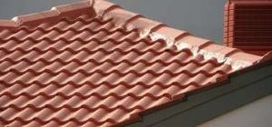 Terracotta roof tiles on a sloped house roof against a gray sky