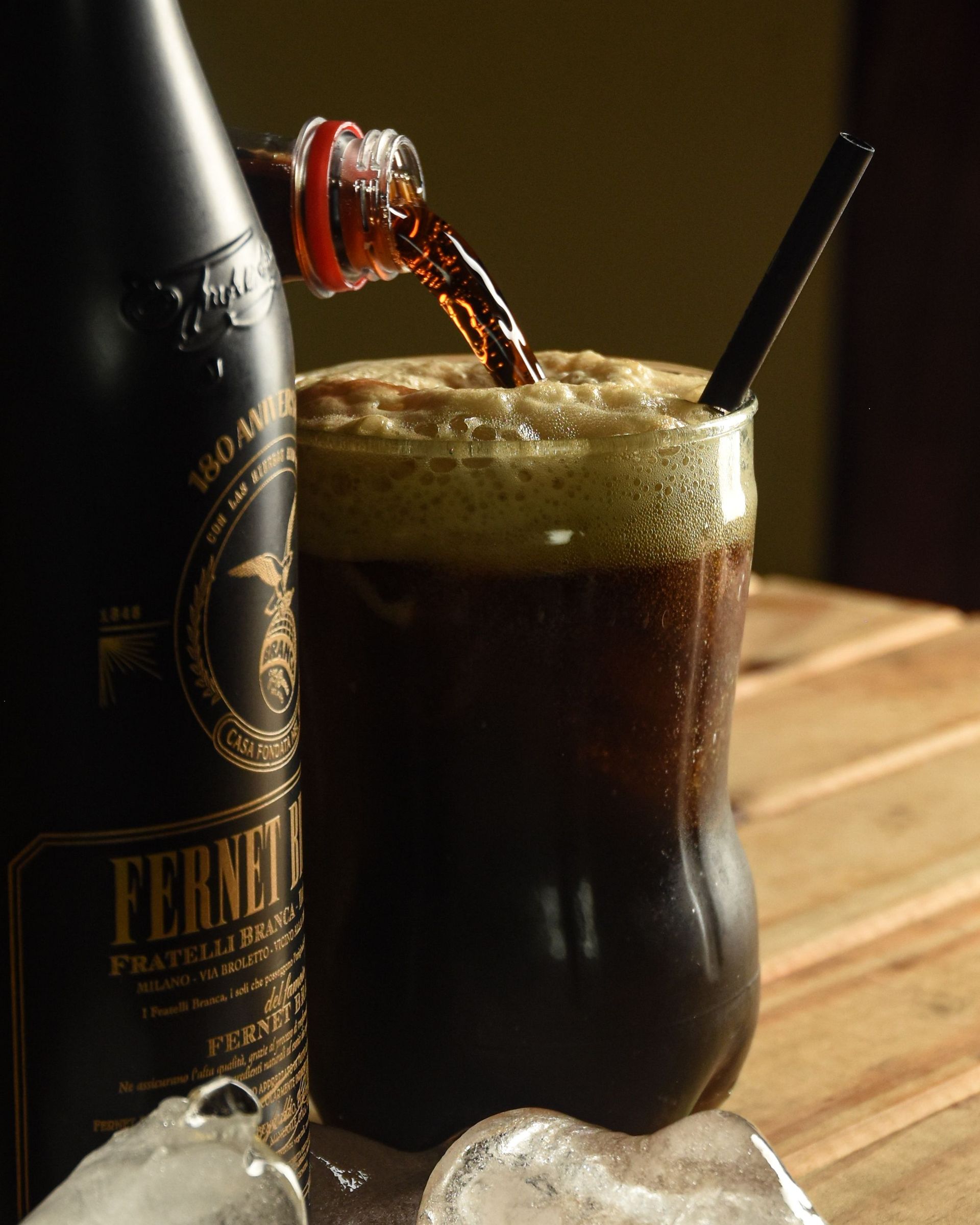 Italian Fernet amaro served over ice with cola, creating a bold drink with herbal, bittersweet flavors.