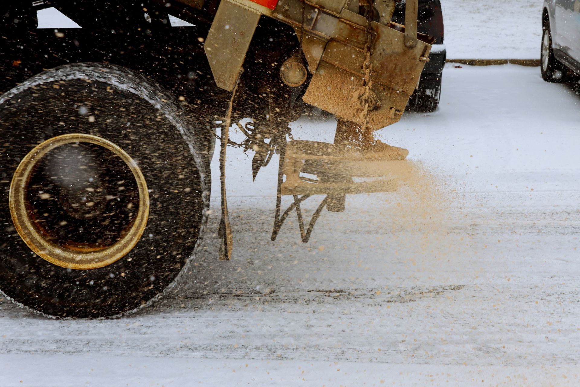 Snow-covered aircraft landing gear on a snowy runway, with a wheel and mechanical parts visible.