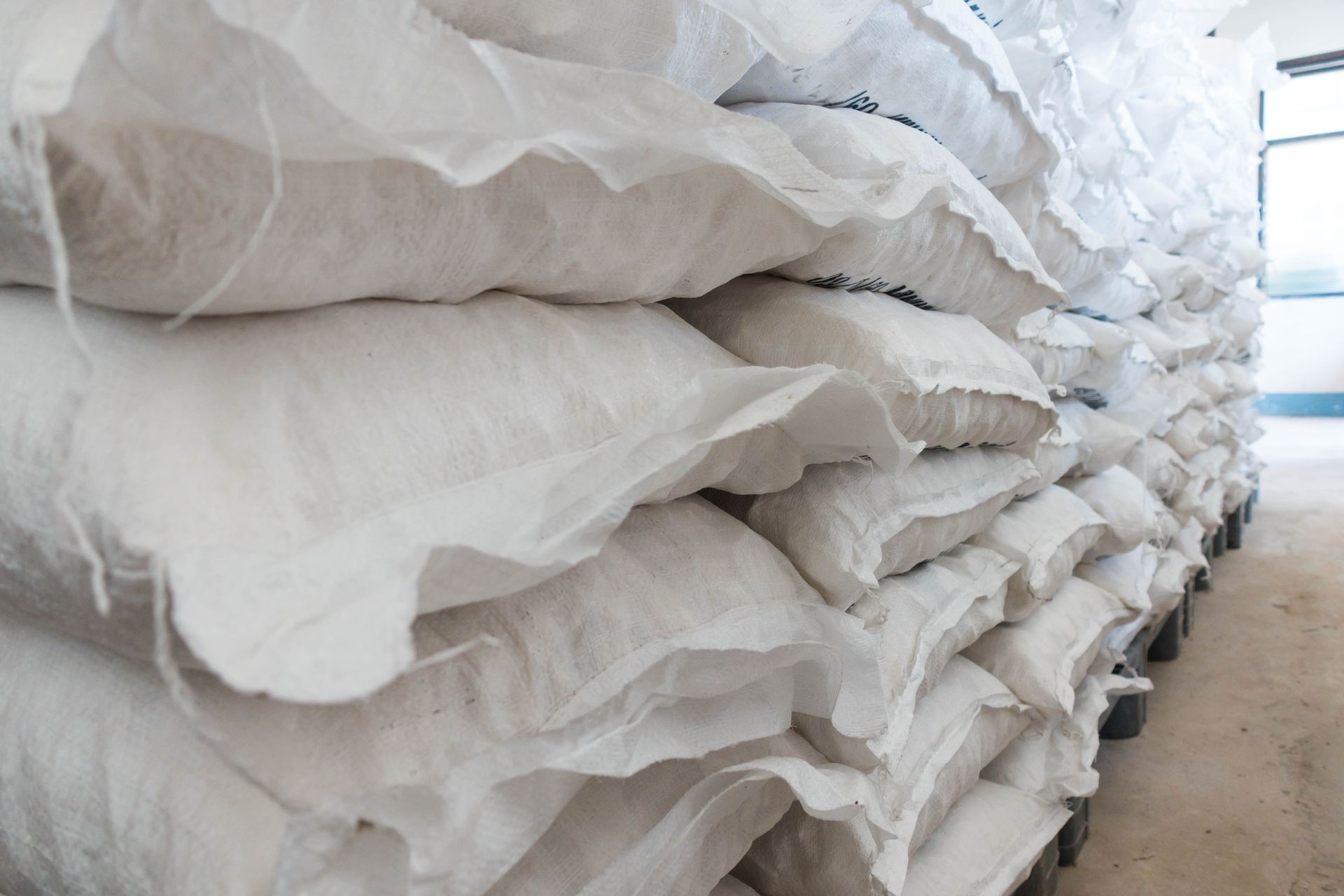 Stacks of white folded fabric sheets piled in a storage area