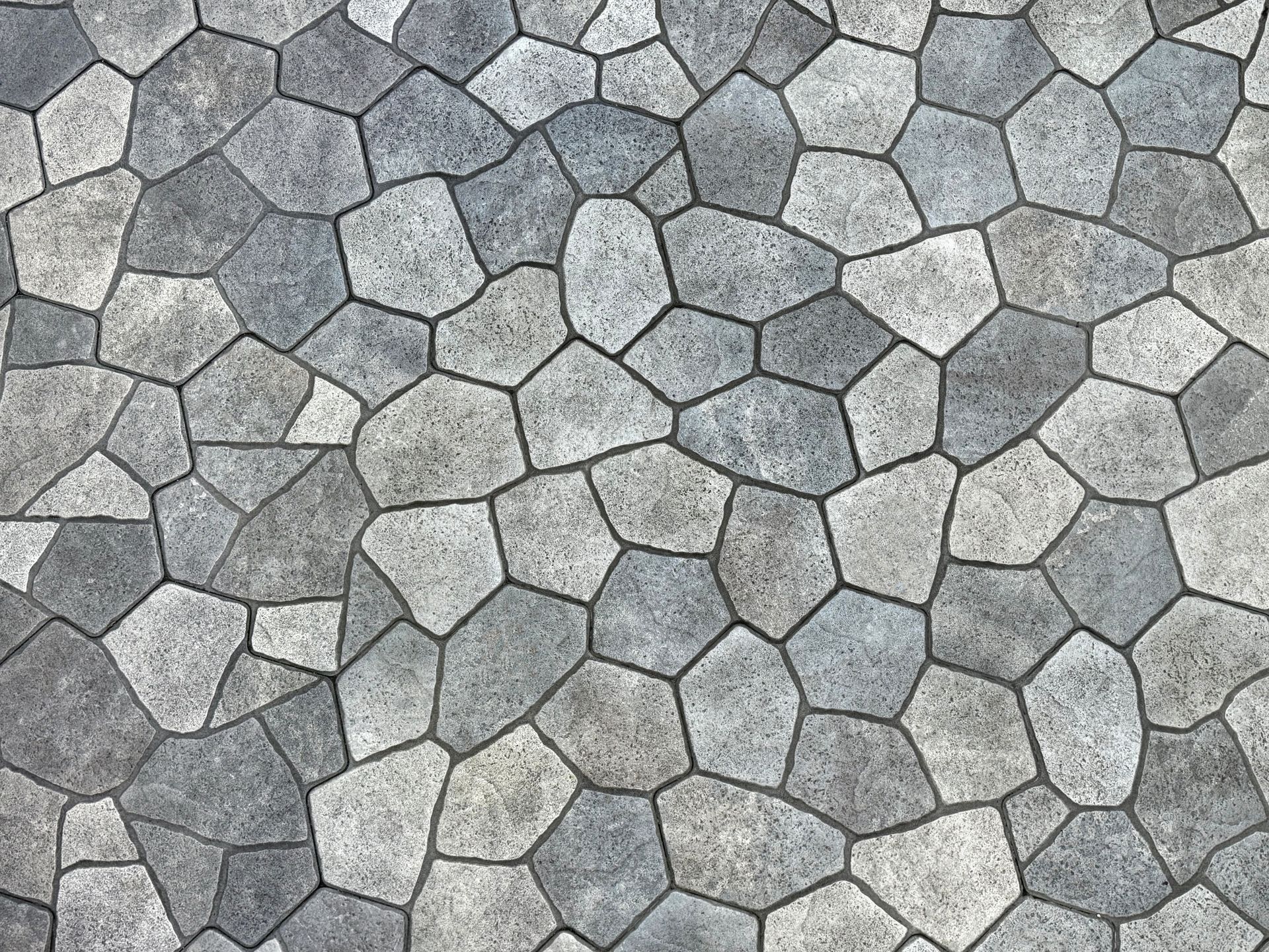 Gray and beige hexagonal stone paving tiles in a repeating pattern