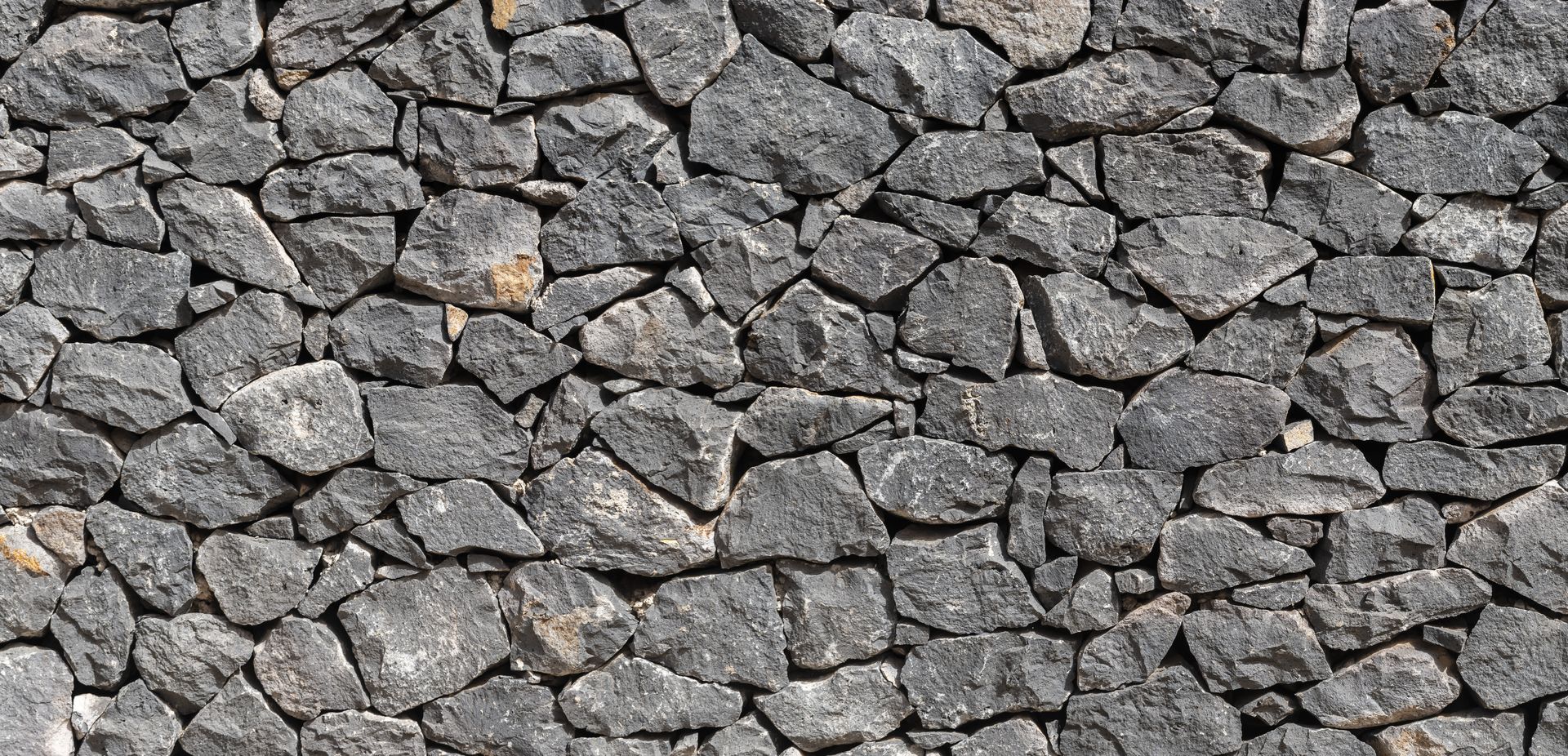 Close-up of gray jagged rocks stacked together in a rough stone surface