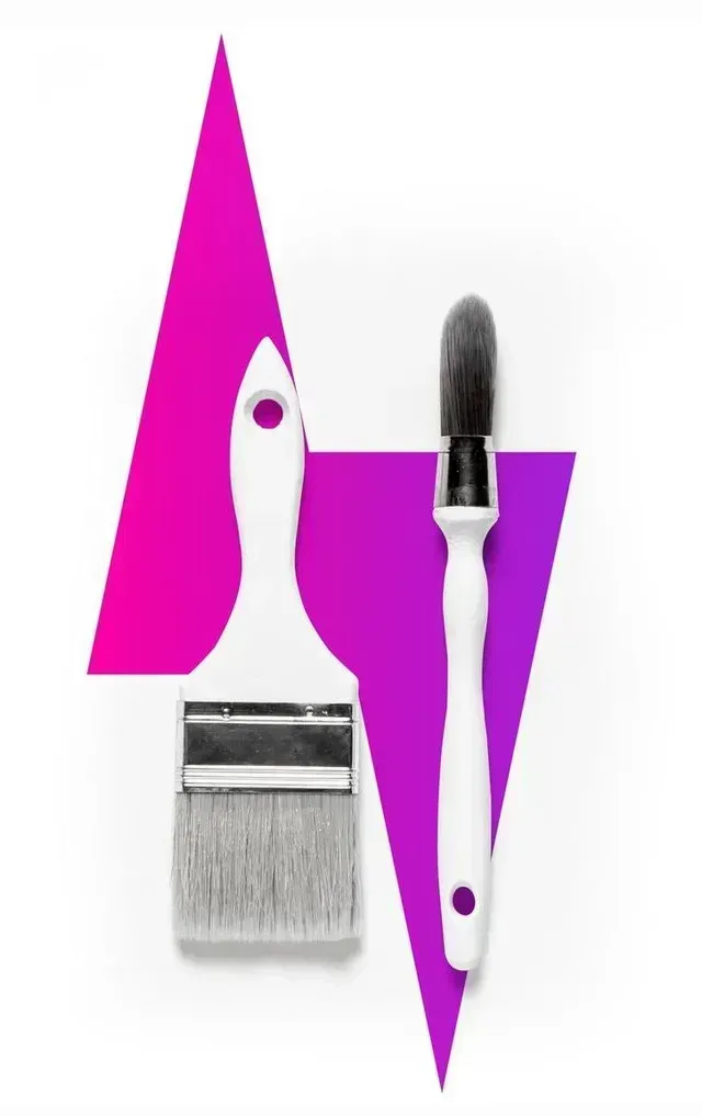Two paintbrushes, one flat and one round, placed over a stylized pink and purple lightning bolt graphic.
