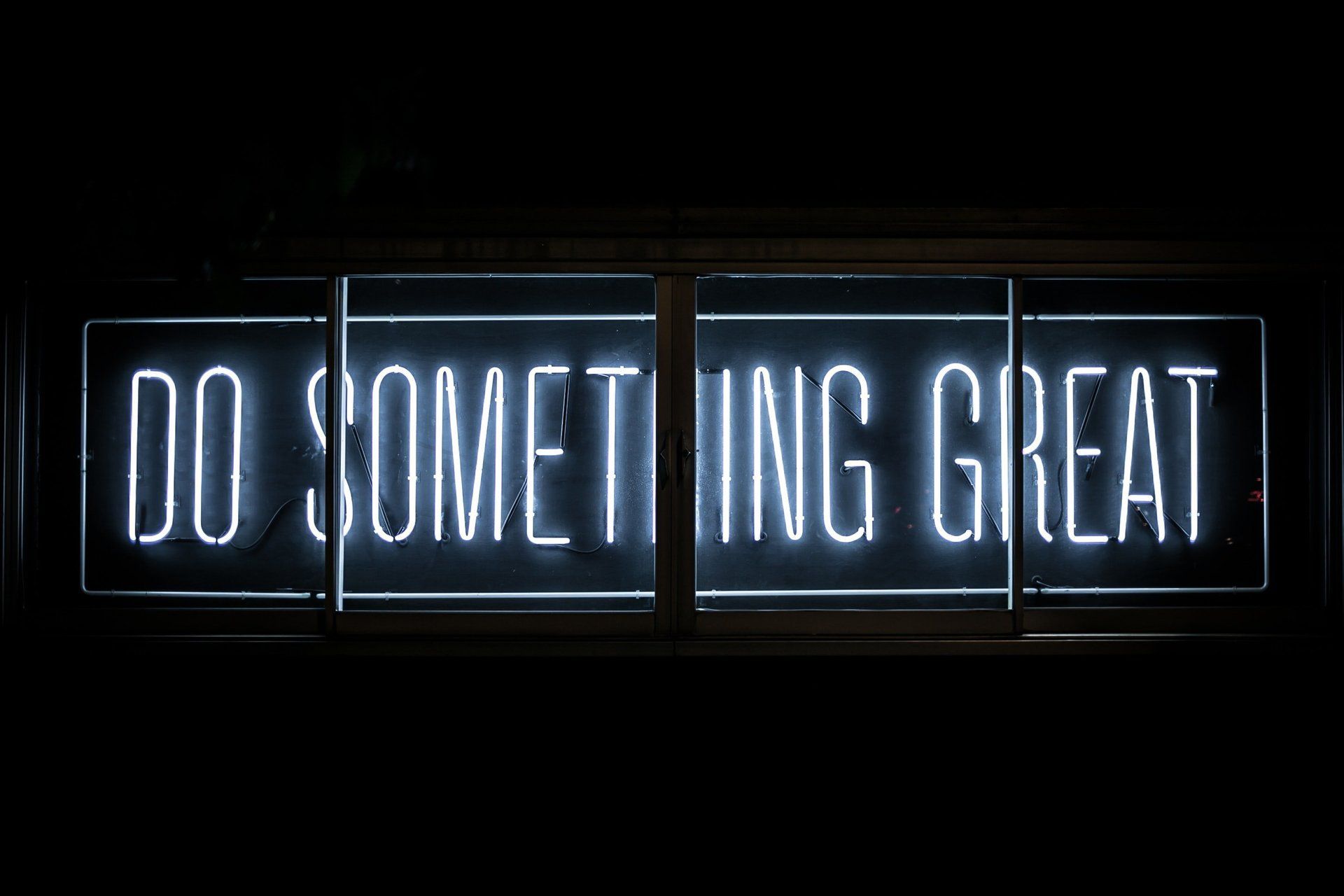 White neon sign against a dark background that reads 