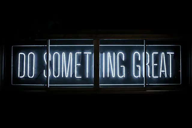 A glowing white neon sign against a black background reads 