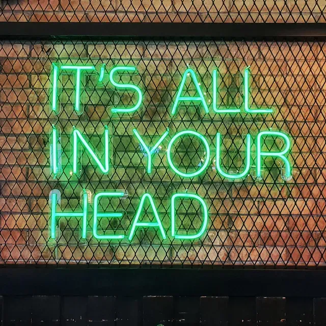 A bright green neon sign reads 
