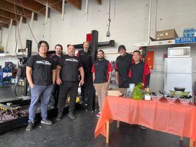 Group of people standing in a workshop beside a table | Miller Auto Repair Shop