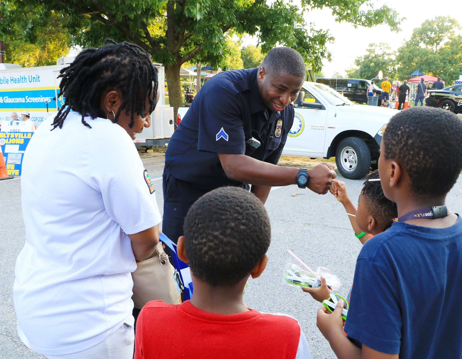 Community officer speaking with children outdoors at a neighborhood event