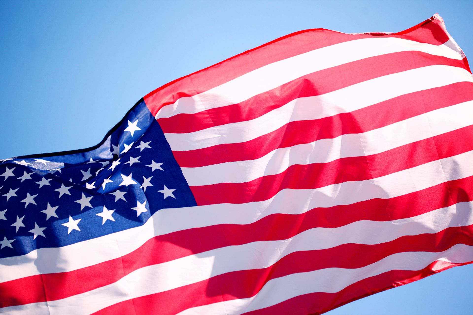 American flag waving against a blue sky
