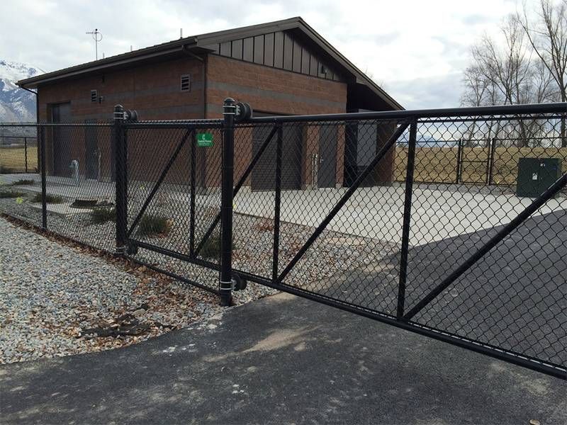 A black chain link fence surrounds a brick building