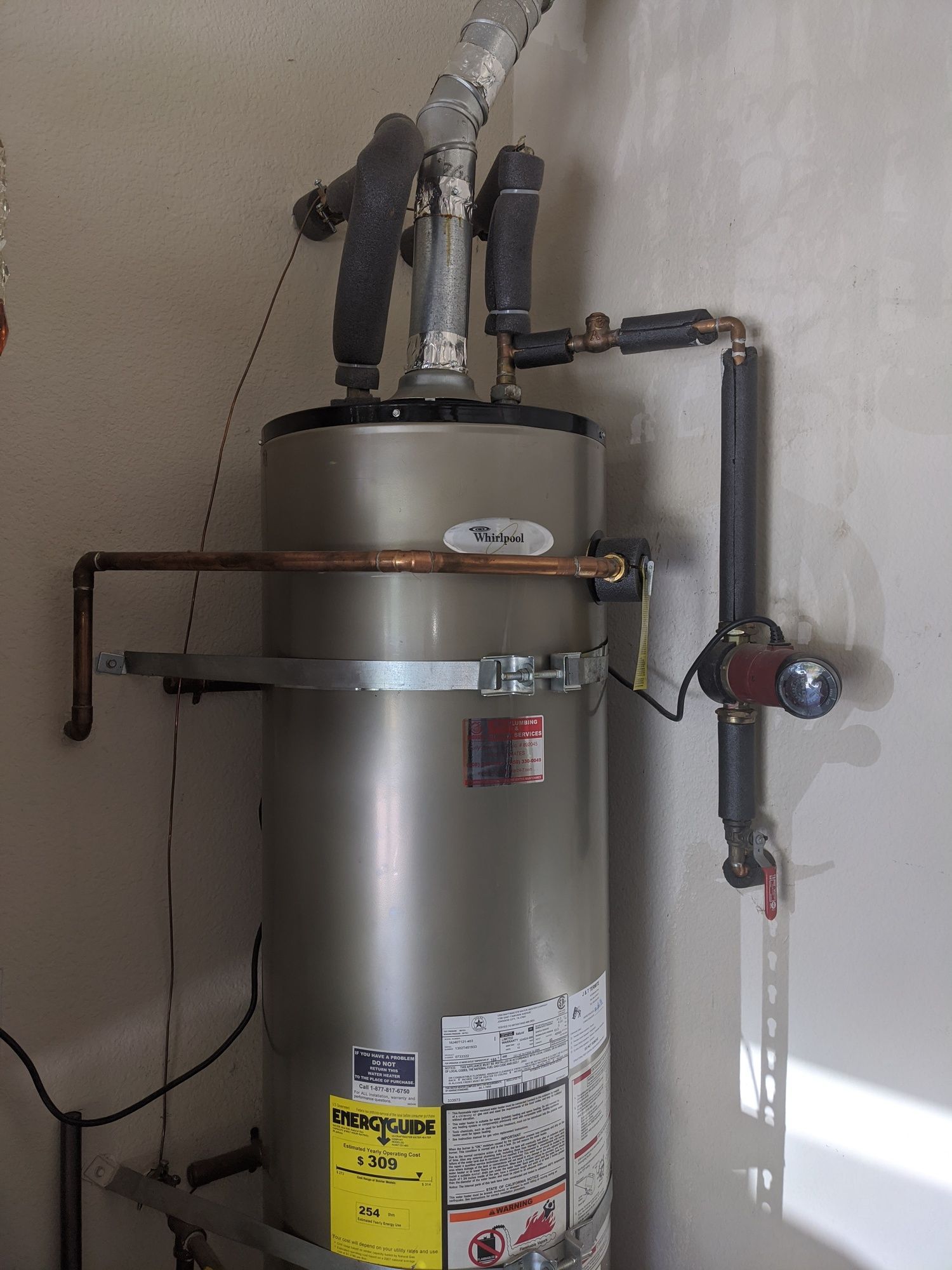 A water heater is hanging on a wall in a room.