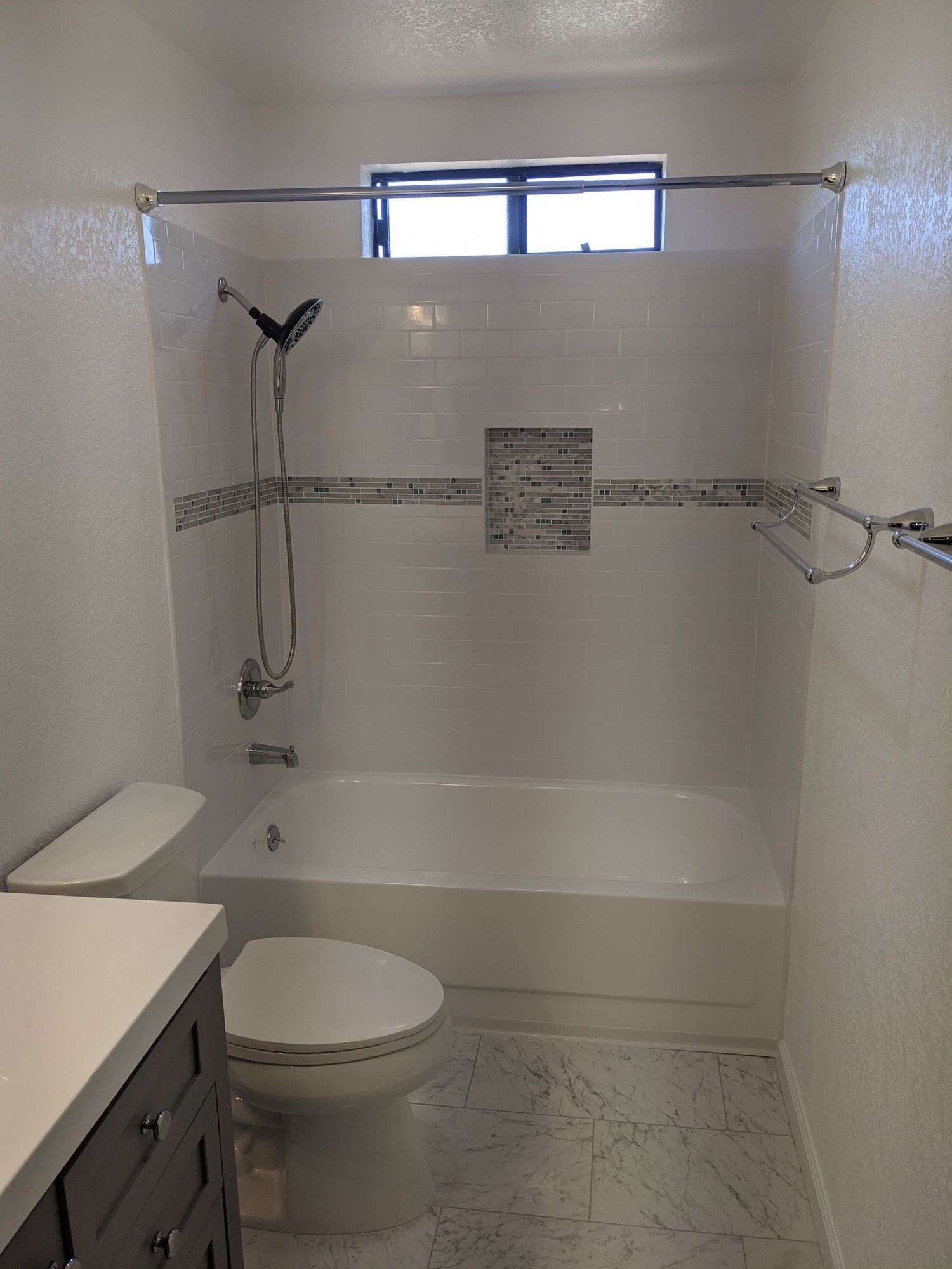 A bathroom with a toilet , bathtub and shower.