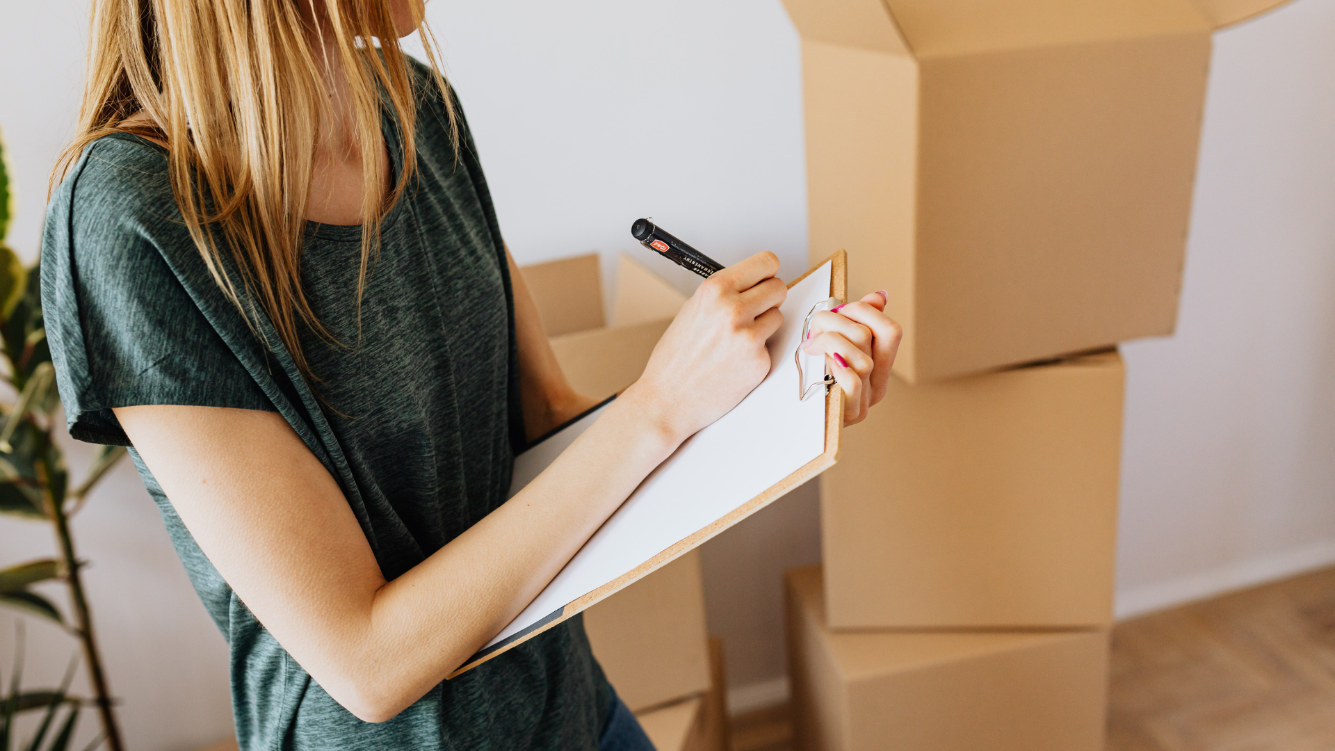 A person making a checklist and preparing for a move by organizing tasks and writing down important