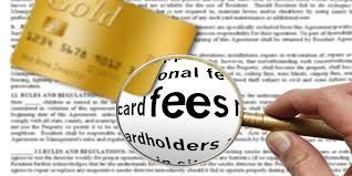 A person is holding a magnifying glass over the word card fees