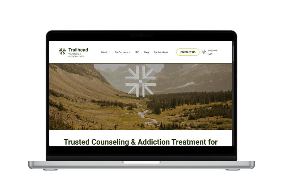 Laptop displaying the Trailhead Counseling & Addiction Treatment website with a landscape photo.