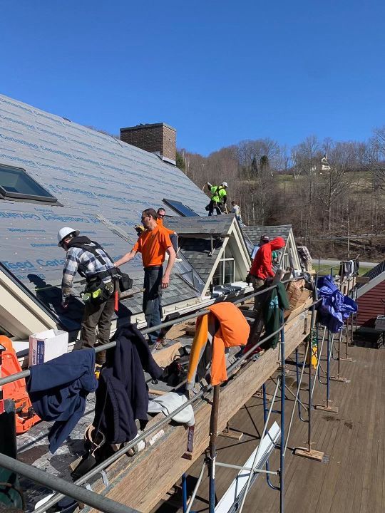Rodd Roofing employee Josh Holycross working with his team preparing a roof