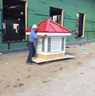 Rodd Roofing employee Josh Holycross pretending to lift a cupola