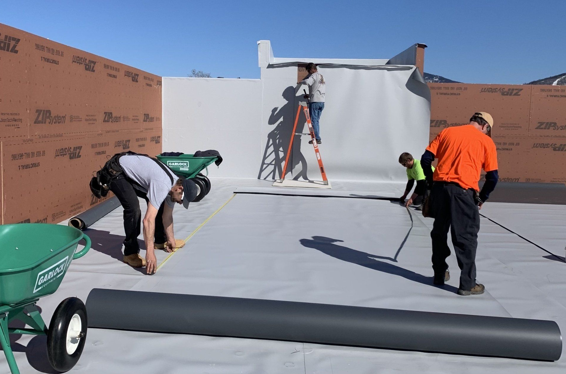 Rood Roofing employees repairing a commercial roof.