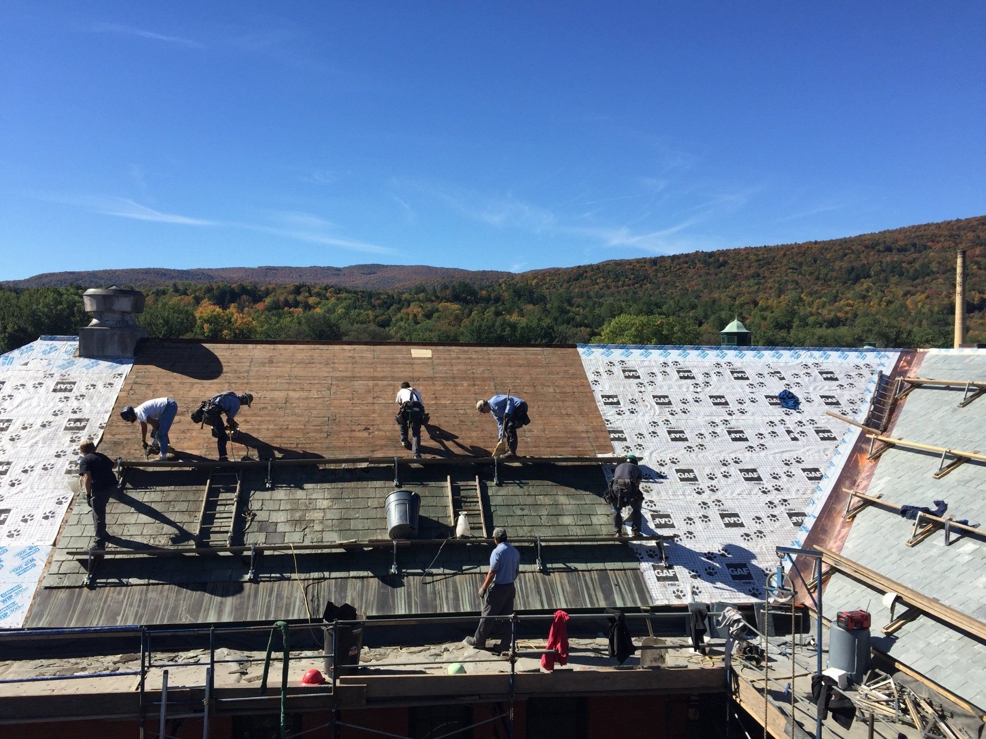 A group of people are working on the roof of a building.