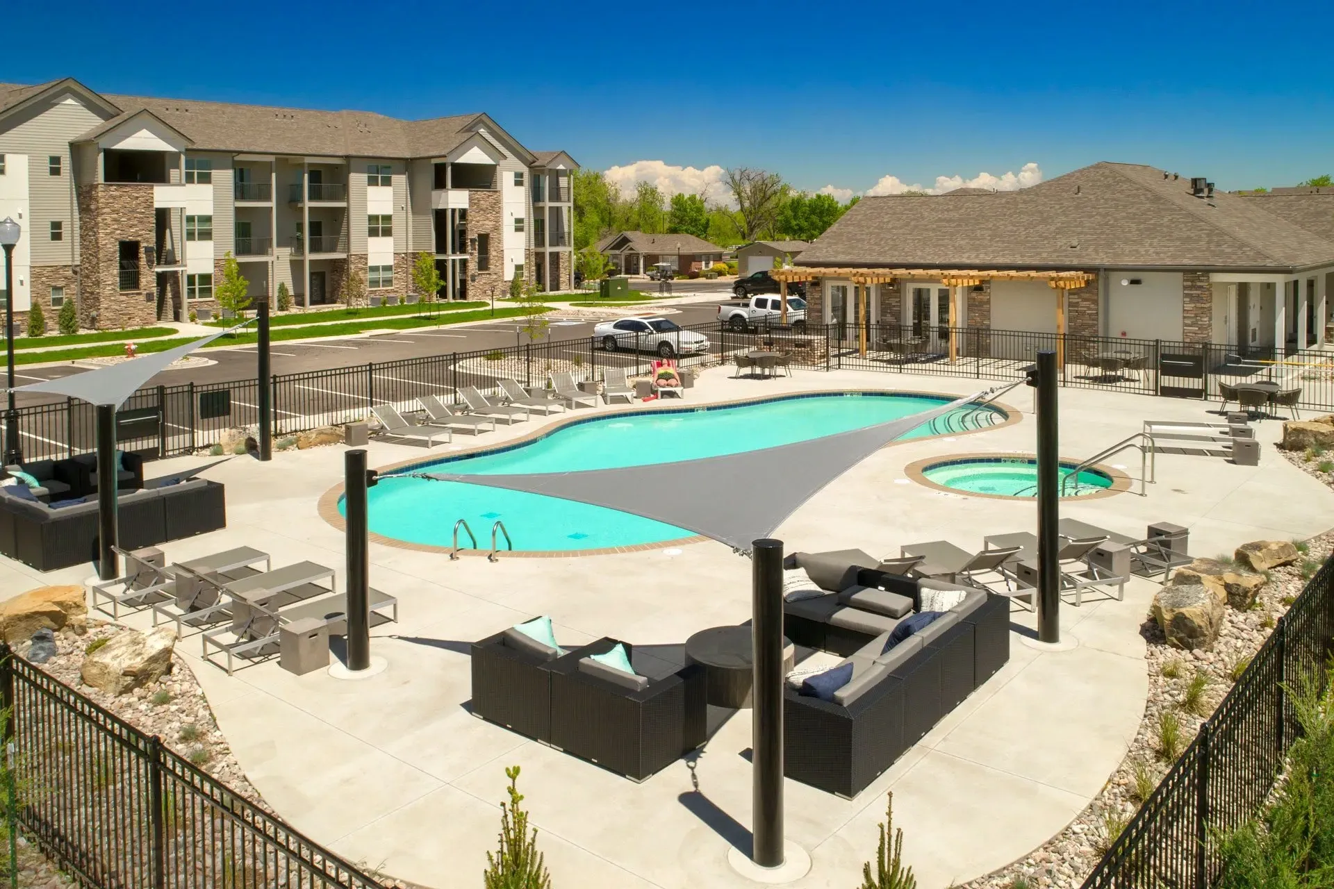 Resort-style outdoor swimming pool and hot tub with lounge chairs and seating areas.
