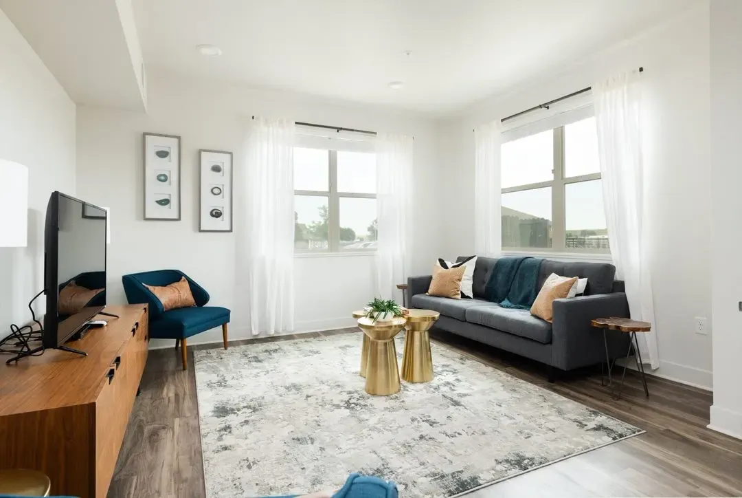 Living room with a gray sofa, blue accent chair, coffee table, and TV.