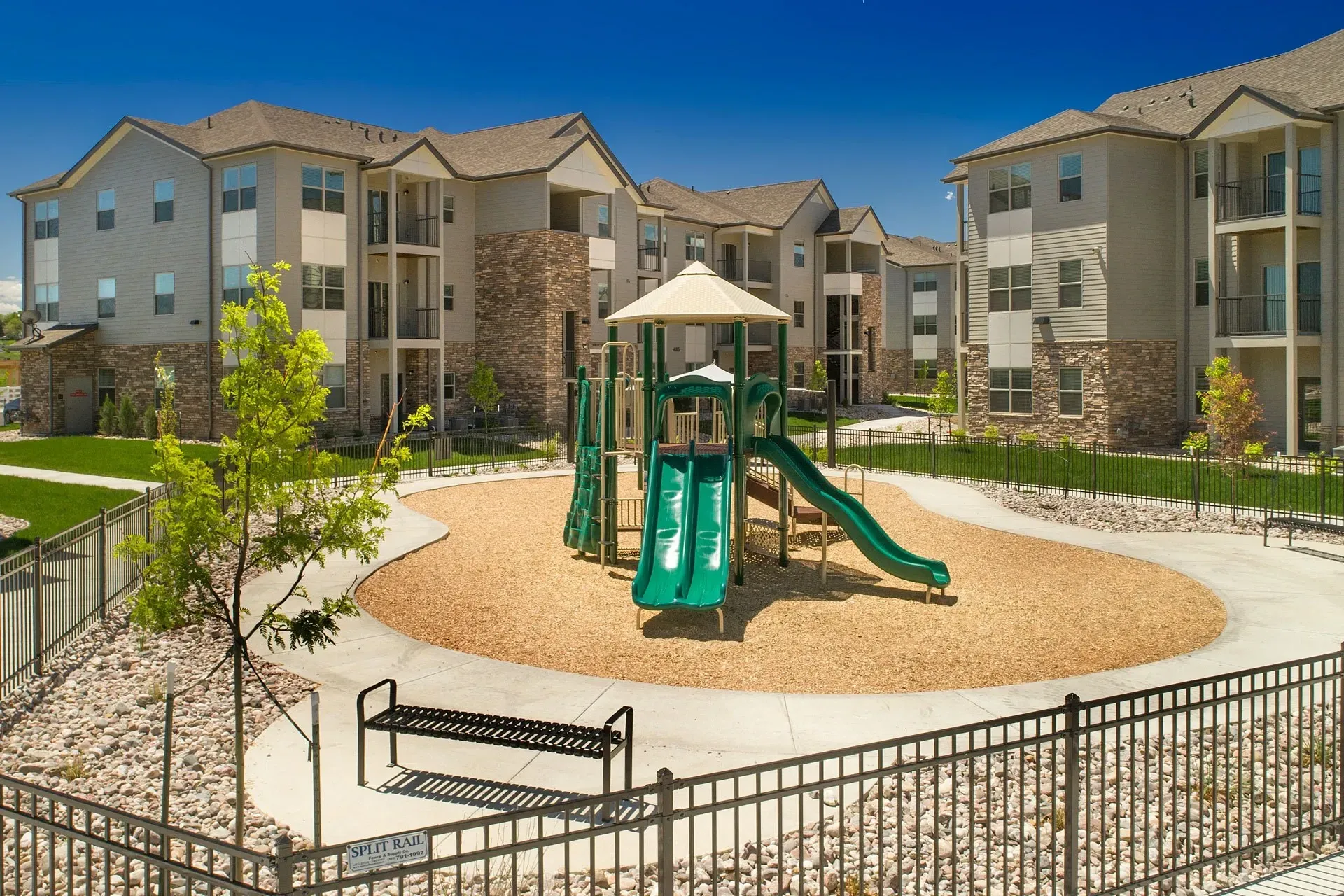 Playground with slides and apartment buildings in the background.