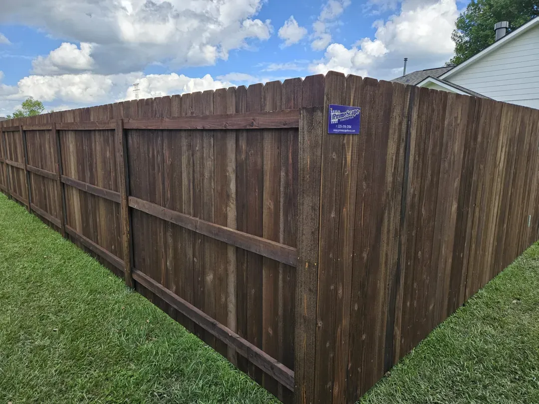 Wooden privacy fence along a grassy yard under a cloudy sky