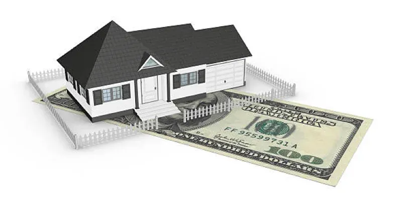 Small house model beside a U.S. dollar bill, representing real estate value or mortgage financing