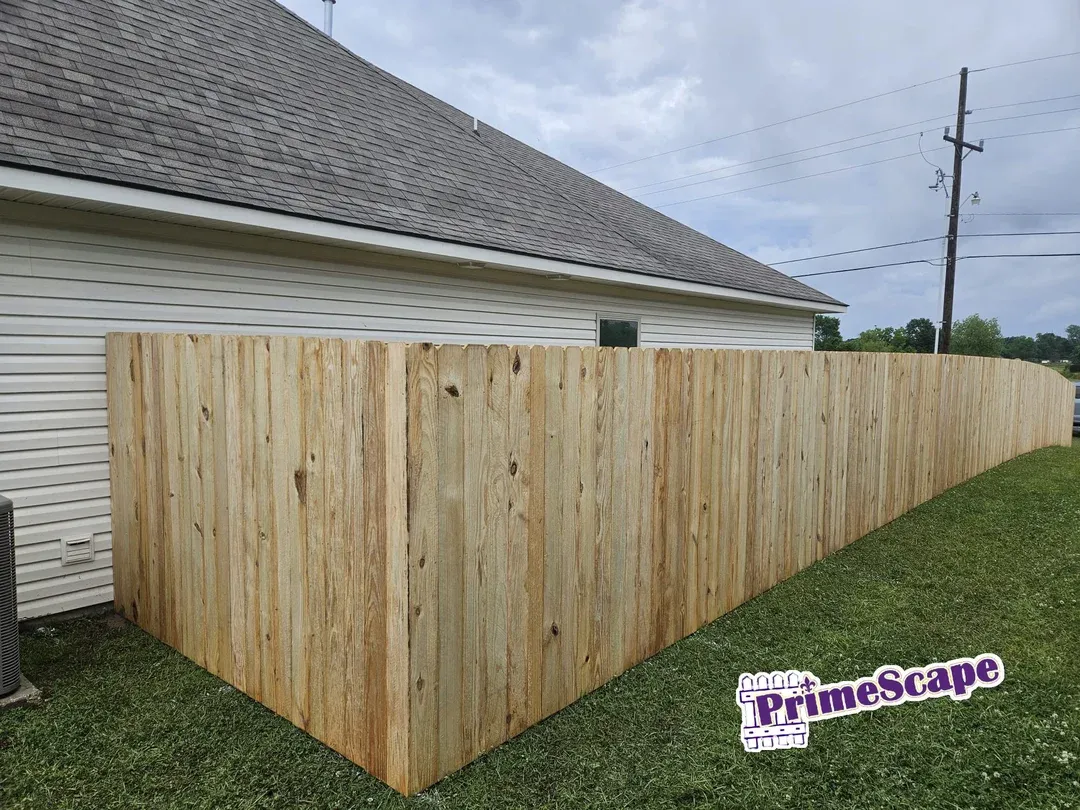 Wooden privacy fence beside a house, enclosing a grassy yard