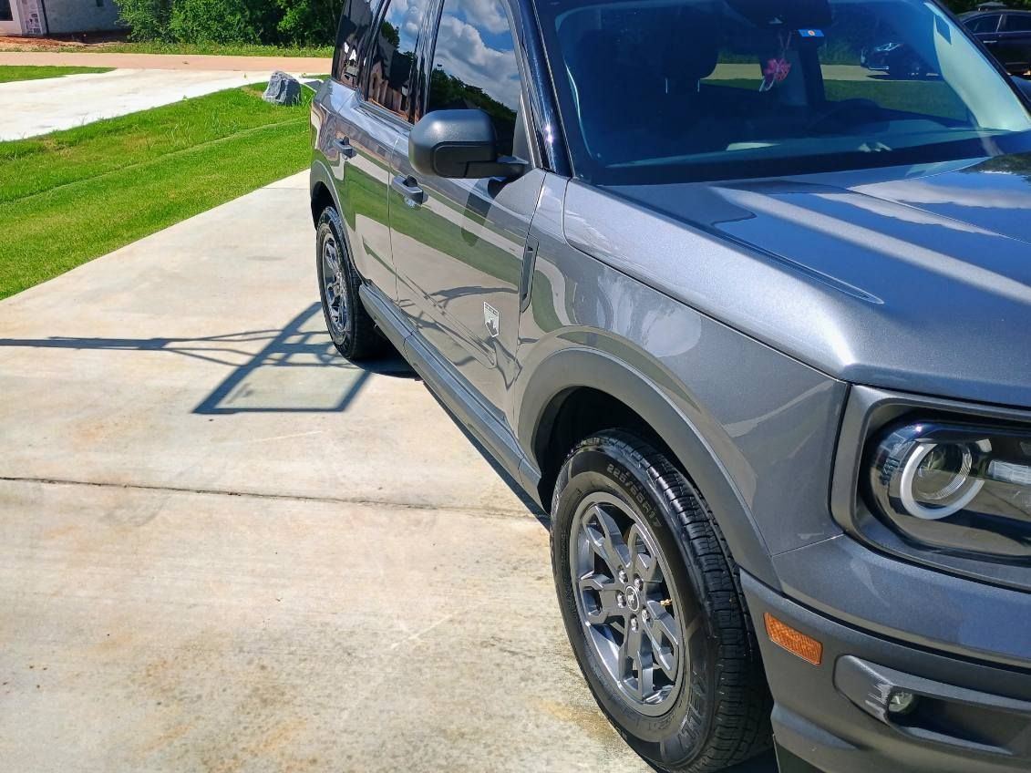 Gray SUV parked in a driveway, front-right view with a bike rack visible on the back.