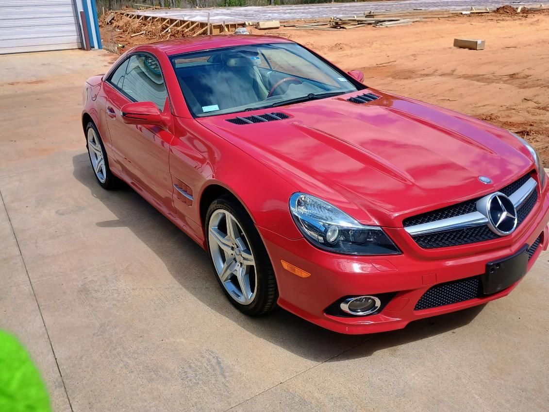 Red Mercedes coupe parked on a concrete driveway outdoors