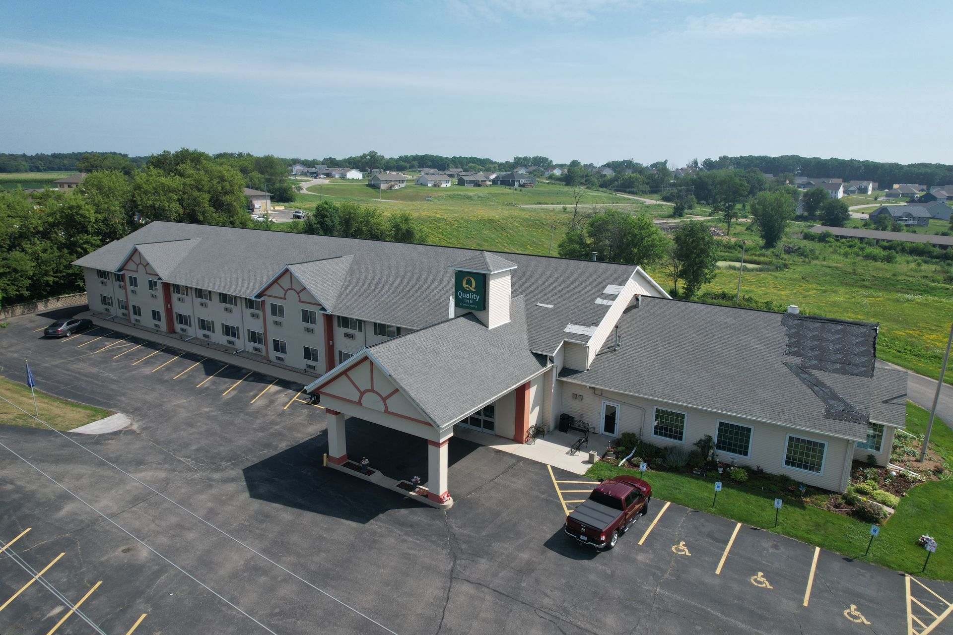An aerial view of a hotel with cars parked in front of it