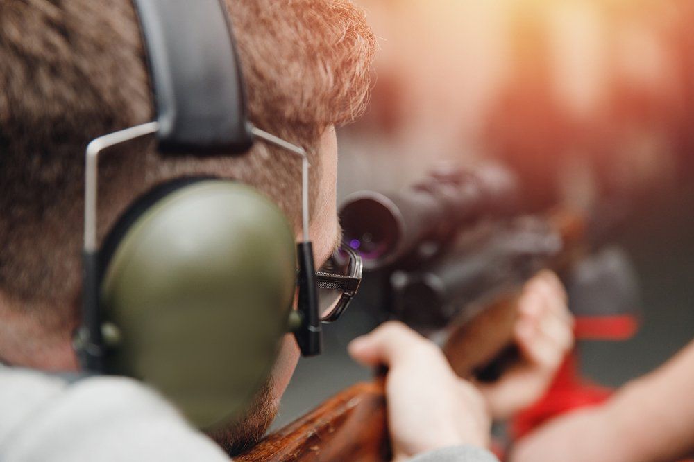 Man directs firearm gun pistol at target firing range or shooting range.