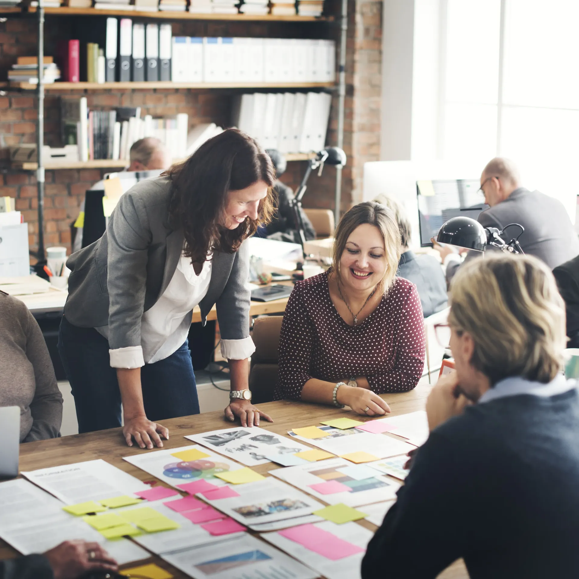 A group of people are sitting around a table with papers on it.