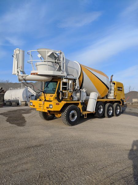 Yellow and white concrete mixer truck