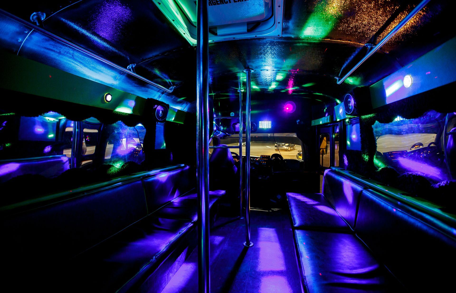 Neon-lit empty bus interior with purple and blue glowing lights and chrome poles