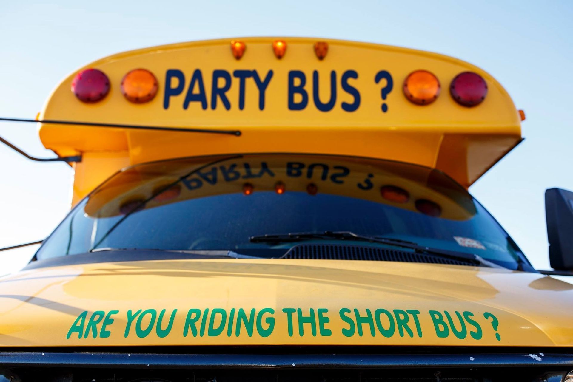 Yellow party bus with “PARTY BUS!” and “ARE YOU RIDING THE SHORT BUS?” text on the front